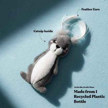 Plush toy resembling an arctic hare with feather ears on a blue background, labeled with features and sustainability information.